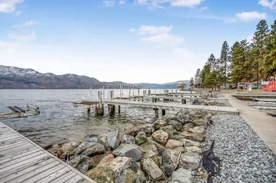 a dock on a body of water with rocks at Beautiful Cabin Right next to Lake Okanagan #5 in West Kelowna