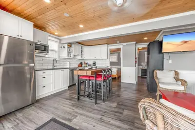 a kitchen with white cabinets and a table with chairs at Lakeside Serenity Retreat #10 in West Kelowna