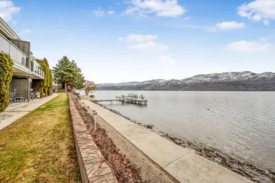 a view of a lake with mountains in the background at Cozy Cottage by the Lakeshore #4 in West Kelowna