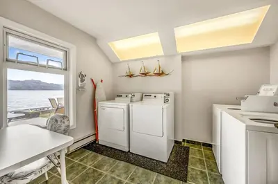 a kitchen with a washer and dryer and a table at Cozy Cottage by the Lakeshore #4 in West Kelowna