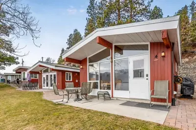 a house with a patio with a table and chairs at Cozy Cottage by the Lakeshore #4 in West Kelowna
