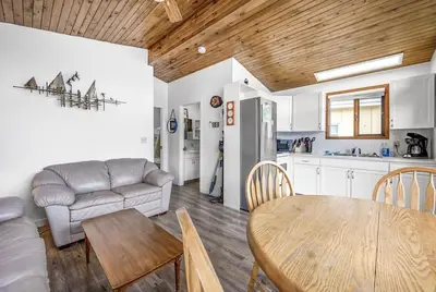 a kitchen and living room with a table and a couch at Cozy Cottage by the Lakeshore #4 in West Kelowna