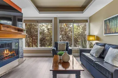 a living room with a couch and a fireplace at Gorgeous Mountain Condo - Hot Tub & Pool managed by Little Sister Getaways in Canmore