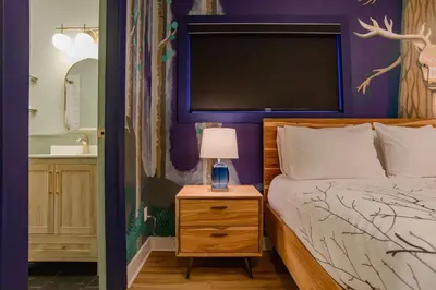 a bedroom with a bed and a night stand with a lamp at Sungate on Salt Spring - Luxurious Suite with Cedar Hot Tub & View in Salt Spring Island