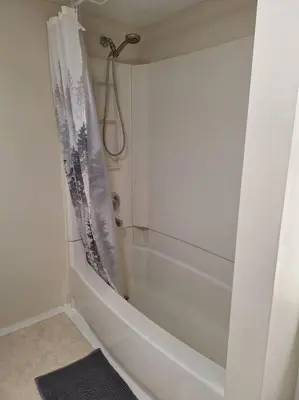 a bathroom with a shower and a white tub at 1-Bedroom Basement Suite in Yellowknife