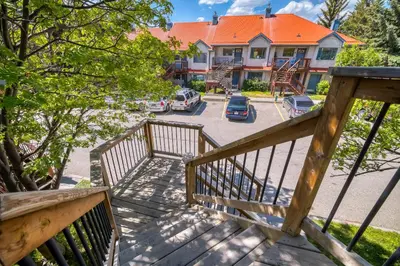 a view from the stairs of a house with a parking lot at Bow Valley Chalets-Entire 2 King Bedrooms townhouse in Canmore