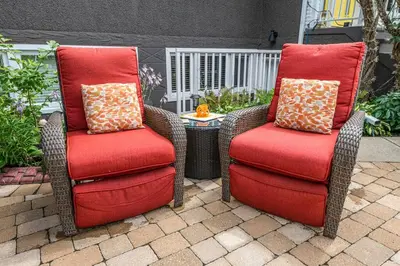 two chairs with red cushions sitting on a patio at YEG Chic Luxury Accommodation in Edmonton
