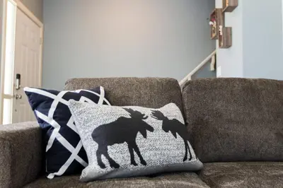 a pillow with a sheep on it sitting on a couch at Modern Home - King Bed - Garage - Long Stays in Edmonton