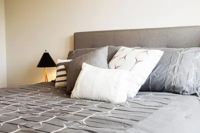 a bed with white pillows on top of it at Modern Home - King Bed - Garage - Long Stays in Edmonton