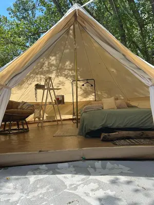 a tent with a bed and a chair on a deck at #Y3 Willow Tree Yurt in Drumheller