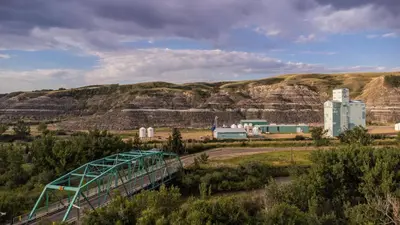 a bridge over a road with a mountain in the background at #Y3 Willow Tree Yurt in Drumheller