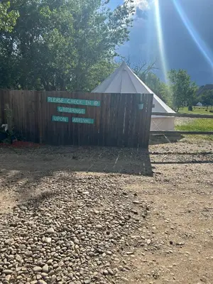 a sign in front of a fence with a tent at #Y4 Aurora Haven Yurt in Drumheller
