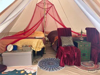 a bedroom with a tent with a bed and a chair at #Y7 Whole New World Yurt in Drumheller