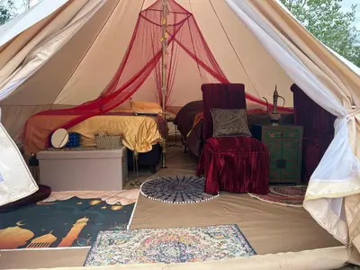 a tent with a bed and a chair in it at #Y7 Whole New World Yurt in Drumheller