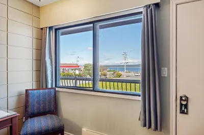 a room with a chair and a window with a view at Big Rock Motel in Campbell River