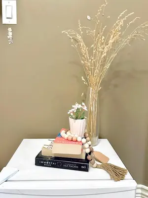 a table with a book and a vase with flowers at Scorpio House Langley -ROOM 1 Separate restroom in Pitt Meadows