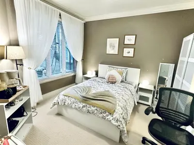 a bedroom with a bed and a chair and a window at Scorpio House Langley -ROOM 1 Separate restroom in Pitt Meadows