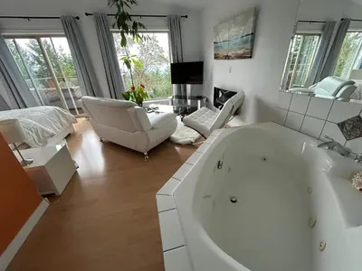 a large white bath tub in a living room with furniture at Armand Heights in Ganges