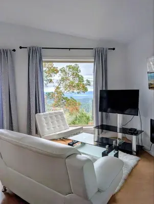 a living room with a white couch and a large window at Armand Heights in Ganges
