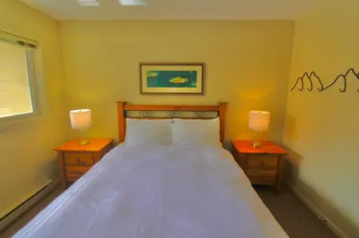 a bedroom with a large bed with two nightstands and two lamps at Timberline Condos - Aspen Building in Fernie