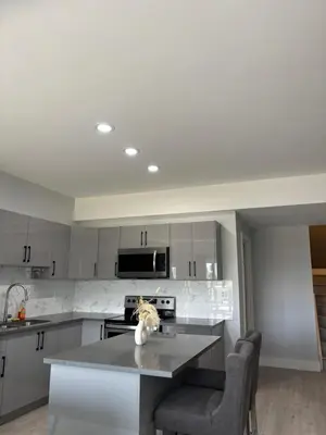 a kitchen with white cabinets and a counter top at Best home with lake view in Edmonton