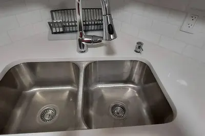 a stainless steel kitchen sink with a faucet at Cozy 2-Bedroom Basement Guest Suite with Private Entrance and Proximity to the Airport in Edmonton