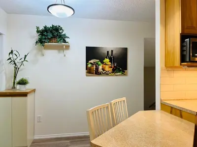 a kitchen with a table and a counter with a picture on the wall at Beautiful home with one acre land for leisure time in Vancouver Island in Nanaimo