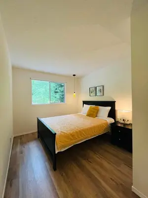 a bedroom with a large bed and a window at Beautiful home with one acre land for leisure time in Vancouver Island in Nanaimo