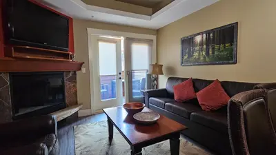 a living room with a couch and a fireplace at Gracie's Place Business license 11787 in Canmore