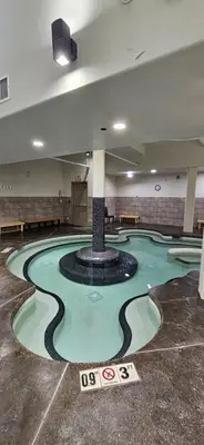 a swimming pool with a fountain in the middle of a building at Gracie's Place Business license 11787 in Canmore