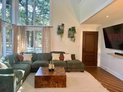 a living room with a green couch and a coffee table at Verde Vista - Steam Shower - Theatre - Ping-Pong in Fairmont Hot Springs