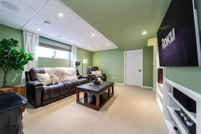 a living room with a couch and a tv at Stylish Euro Vibes Home, Small Gym, AC, Yard, Office in Edmonton