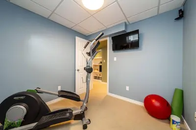 a room with a gym with a treadmill at Stylish Euro Vibes Home, Small Gym, AC, Yard, Office in Edmonton