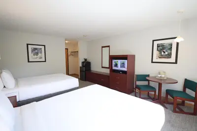 a hotel room with two beds and a table at Glacier Mountain Lodge in Blue River