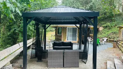 a black gazebo with a couch under it at Cabin in the woods @ Cultus Lake in Chilliwack