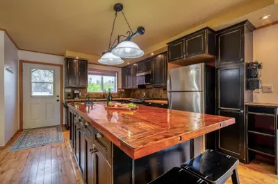a kitchen with a wooden counter top and a refrigerator at Radium 5BR Home Ping Pong, Foosball, & Gazebo in Radium Hot Springs
