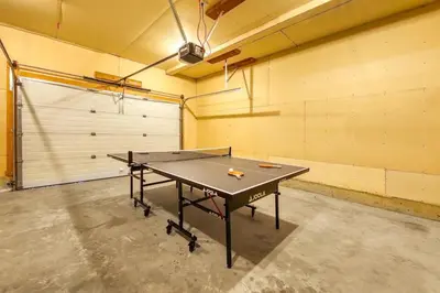 a ping pong table in a room with a garage at Radium 5BR Home Ping Pong, Foosball, & Gazebo in Radium Hot Springs