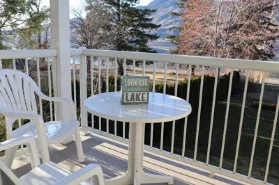 a table and chairs on a porch with a book on it at Blue Shore Resort in Savona