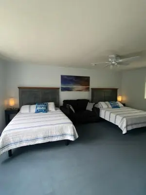 a bedroom with two beds and a couch at Blue Shore Resort in Savona