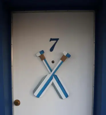 a white clock with blue hands and crosses on it at Blue Shore Resort in Savona