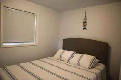 a bed with two pillows and a window in a bedroom at Blue Shore Resort in Savona