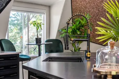 a kitchen with a sink and some green chairs at Dome House YYC, Iconic, Luxury, Backyard Oasis in Calgary