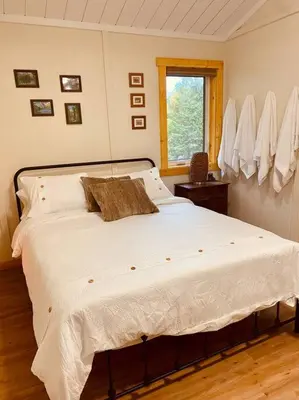 a bedroom with a large white bed with a window at Ski-In Chalet: Private Hot tub, Bonus Bunk House in Fernie