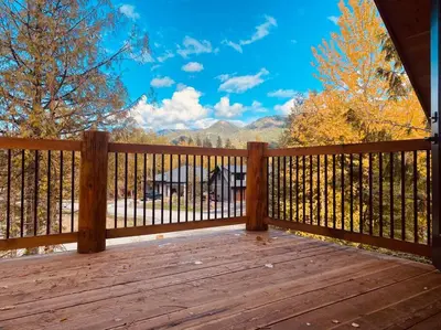 a wooden deck with a view of the mountains at Ski-In Chalet: Private Hot tub, Bonus Bunk House in Fernie