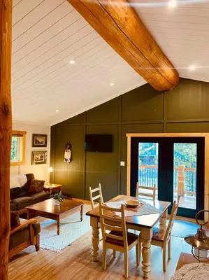 a living room with a table and a couch at Ski-In Chalet: Private Hot tub, Bonus Bunk House in Fernie