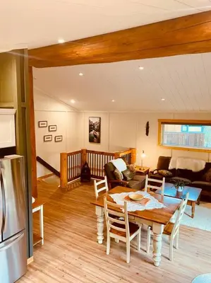a kitchen and living room with a table and chairs at Ski-In Chalet: Private Hot tub, Bonus Bunk House in Fernie