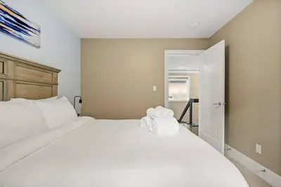 a bedroom with a large white bed with two towels on it at Large Detached Near Anthony Henday in Albany with 2 Living Rooms, Netflix, Office Space, AC, Perfect for Families, Sleeps 13 in Edmonton
