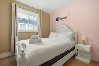 a bedroom with a white bed with two towels on it at Large Detached Near Anthony Henday in Albany with 2 Living Rooms, Netflix, Office Space, AC, Perfect for Families, Sleeps 13 in Edmonton