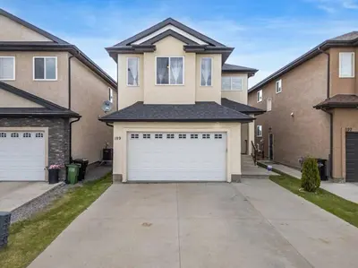 a house with two garage doors in a driveway at Large Detached Near Anthony Henday in Albany with 2 Living Rooms, Netflix, Office Space, AC, Perfect for Families, Sleeps 13 in Edmonton