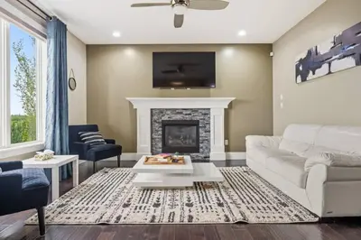 a living room with a white couch and a fireplace at Large Detached Near Anthony Henday in Albany with 2 Living Rooms, Netflix, Office Space, AC, Perfect for Families, Sleeps 13 in Edmonton